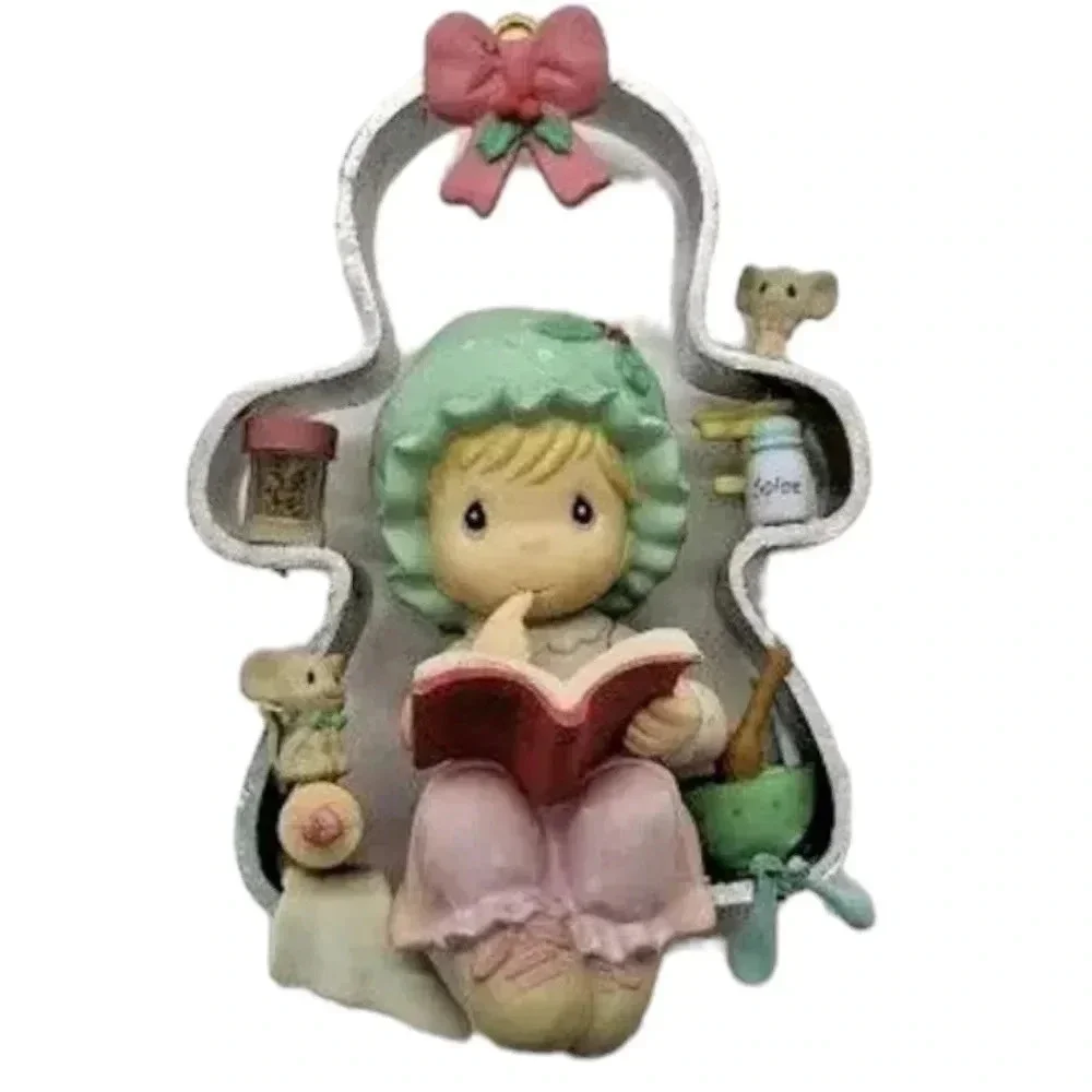 Precious moments girl perched on a cookie cutter christmas ornament